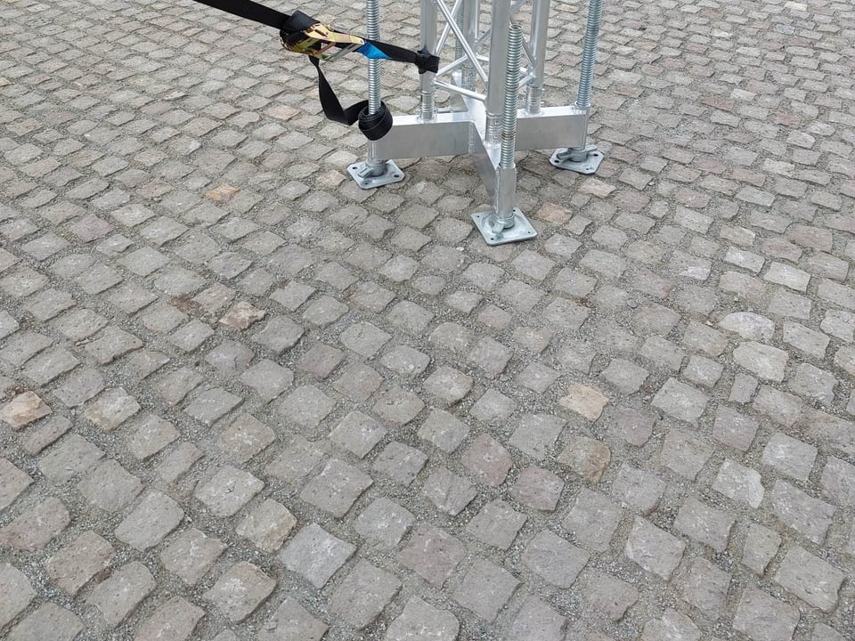 A színpadfedés oszloptalpa szintezőkkel és kikötőhevederrel a térkövön